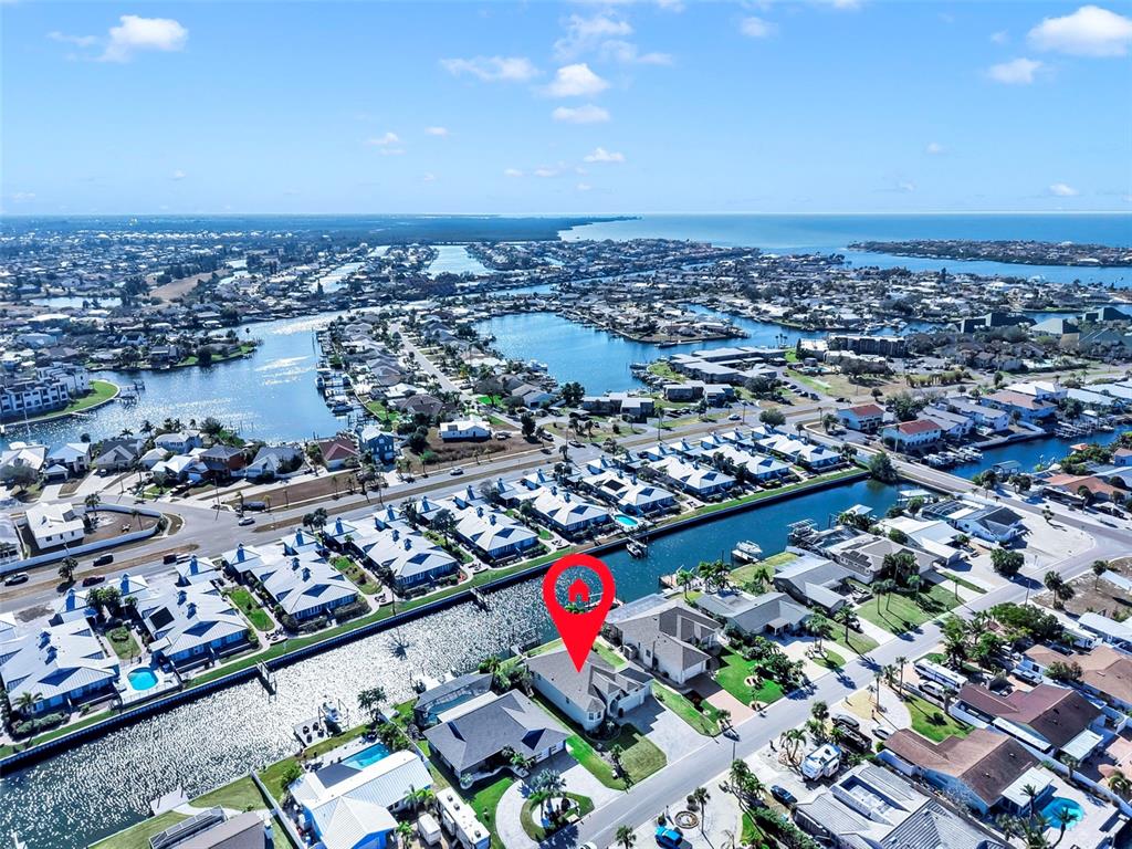 An aerial view shows a residential neighborhood with houses situated along a canal — 916 SPINDLE PALM WAY, APOLLO BEACH, FL