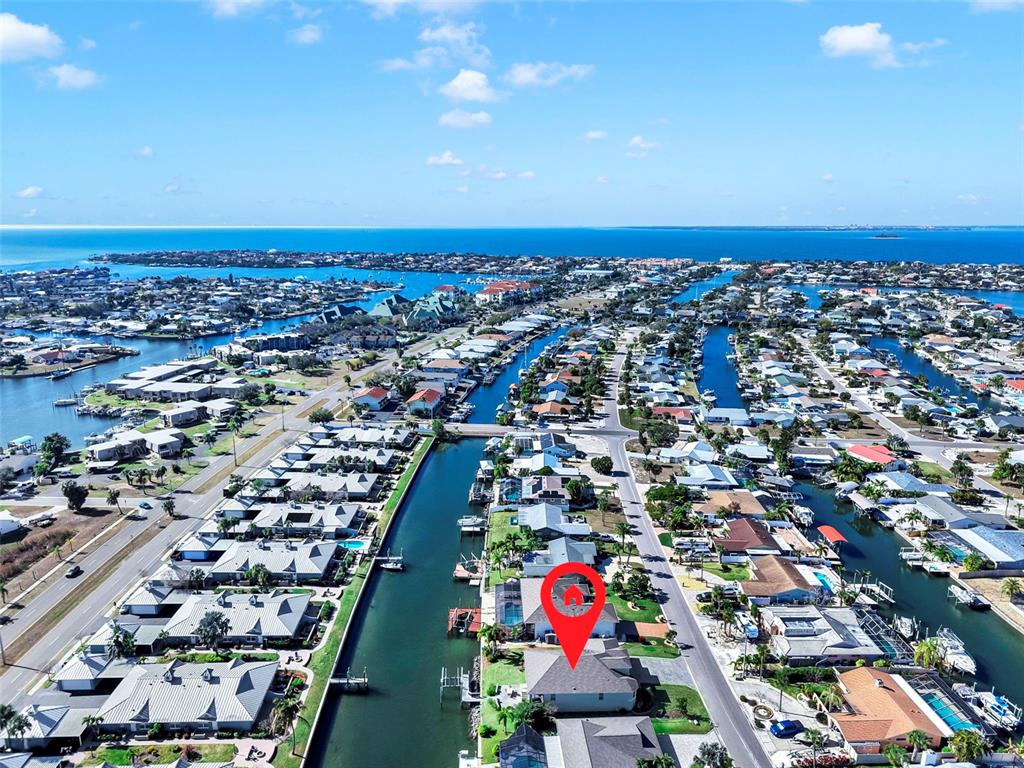 An aerial view shows a residential neighborhood with houses lining a canal — 916 SPINDLE PALM WAY, APOLLO BEACH, FL