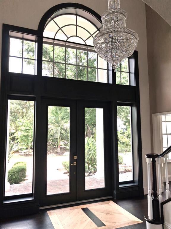 An entryway features a black double door, a large arched window, and a crystal chandelier — 3171 DICK WILSON DRIVE, SARASOTA, FL
