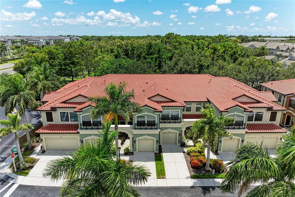 An aerial view of a multi-unit residential building with a red tile roof and palm trees — 4991 OARSMAN COURT, SARASOTA, FL
