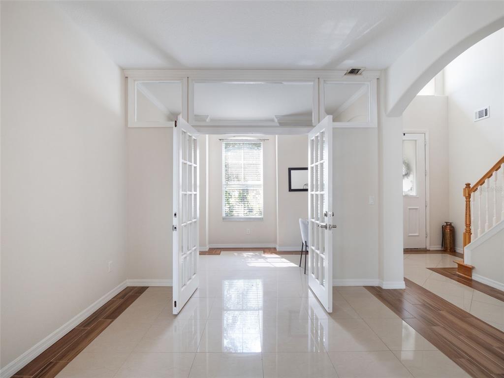 A room with light tile flooring and French doors leading to an adjacent sunlit space — 13156 HATHERTON CIRCLE, ORLANDO, FL