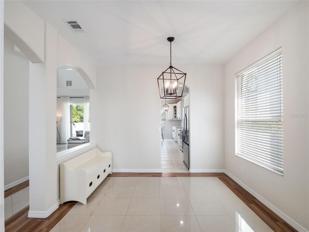 A dining area features a lantern pendant light, white bench, and tile flooring with wood trim — 13156 HATHERTON CIRCLE, ORLANDO, FL