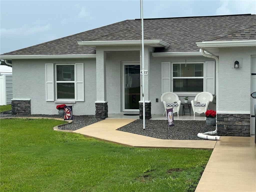 A single-story house exterior features a gray stucco facade, stone accents, and a front porch — 4322 E MARYLAND STREET, INVERNESS, FL