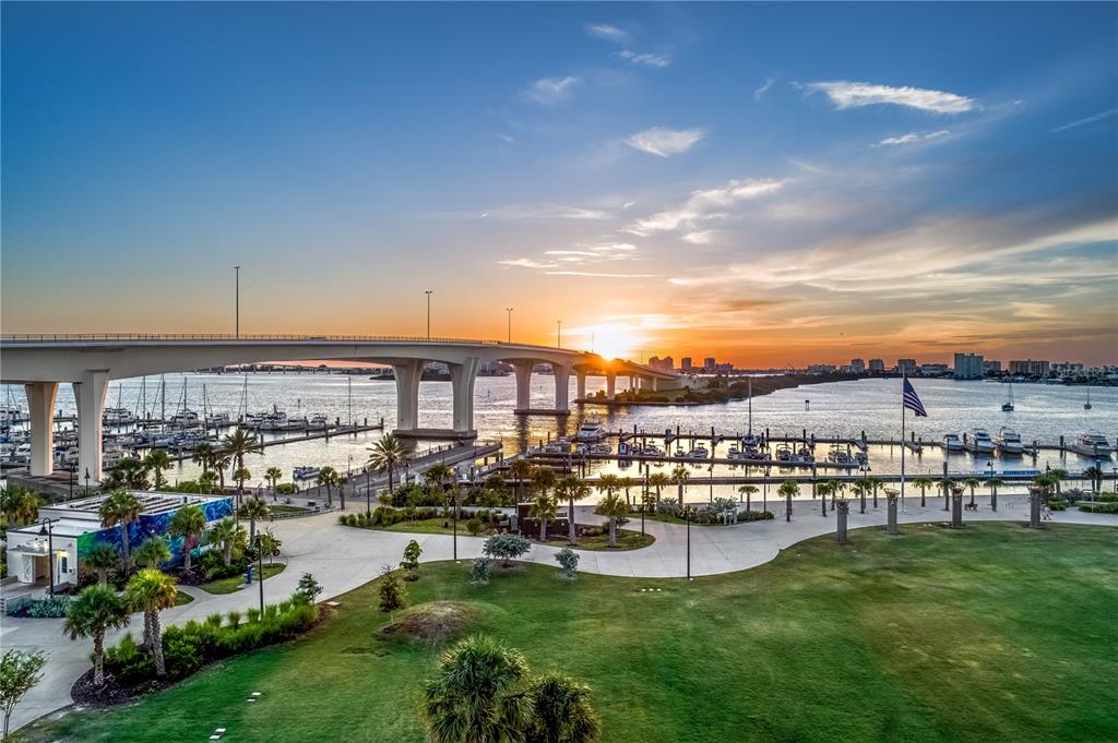 An elevated view of a waterfront park, marina, and bridge at sunset — 331 CLEVELAND STREET UNIT 213, CLEARWATER, FL