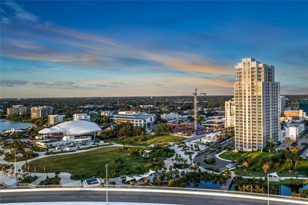 An aerial view shows a park, a large white pavilion, and a tall residential building — 331 CLEVELAND STREET UNIT 213, CLEARWATER, FL