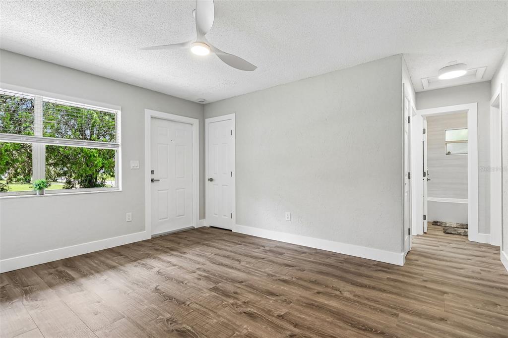 A room with light gray walls, wood-look flooring, a ceiling fan, and a white door — 1062 BARCLAY DRIVE, COCOA, FL