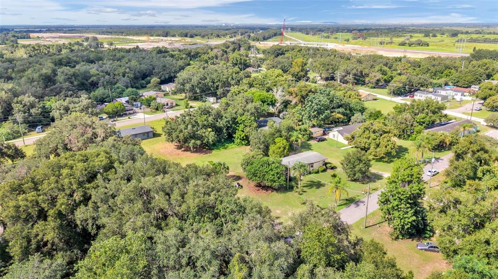 An aerial view shows several houses nestled among dense trees and green lawns — 0 PERCH STREET, BARTOW, FL