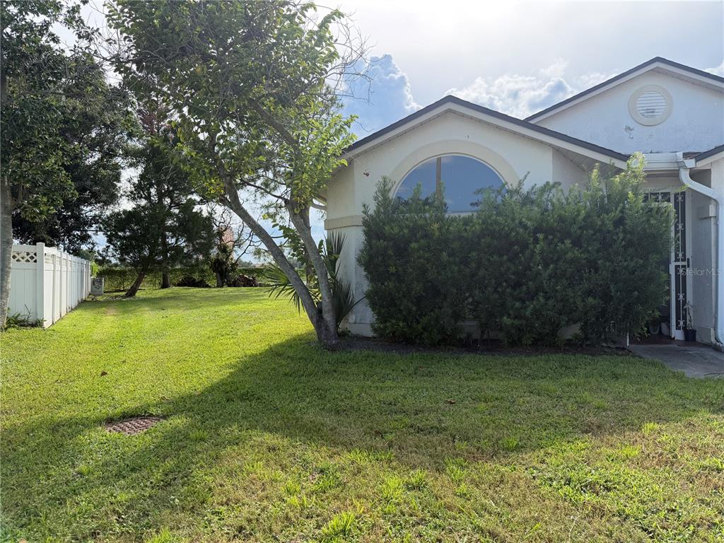 A white house exterior features a large arched window, a front door, and a grassy yard — 3236 KOVAL COURT, ORLANDO, FL