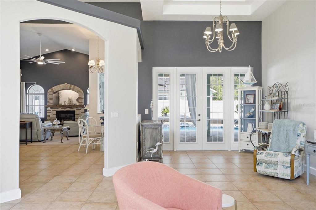 A living room with tile floors, a pink chair, and a view into a dining area — 20 EVANSTON LANE, PALM COAST, FL