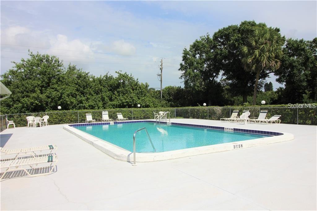 An outdoor rectangular swimming pool with a concrete deck and lounge chairs — 7287 ELEANOR CIRCLE UNIT 15, SARASOTA, FL
