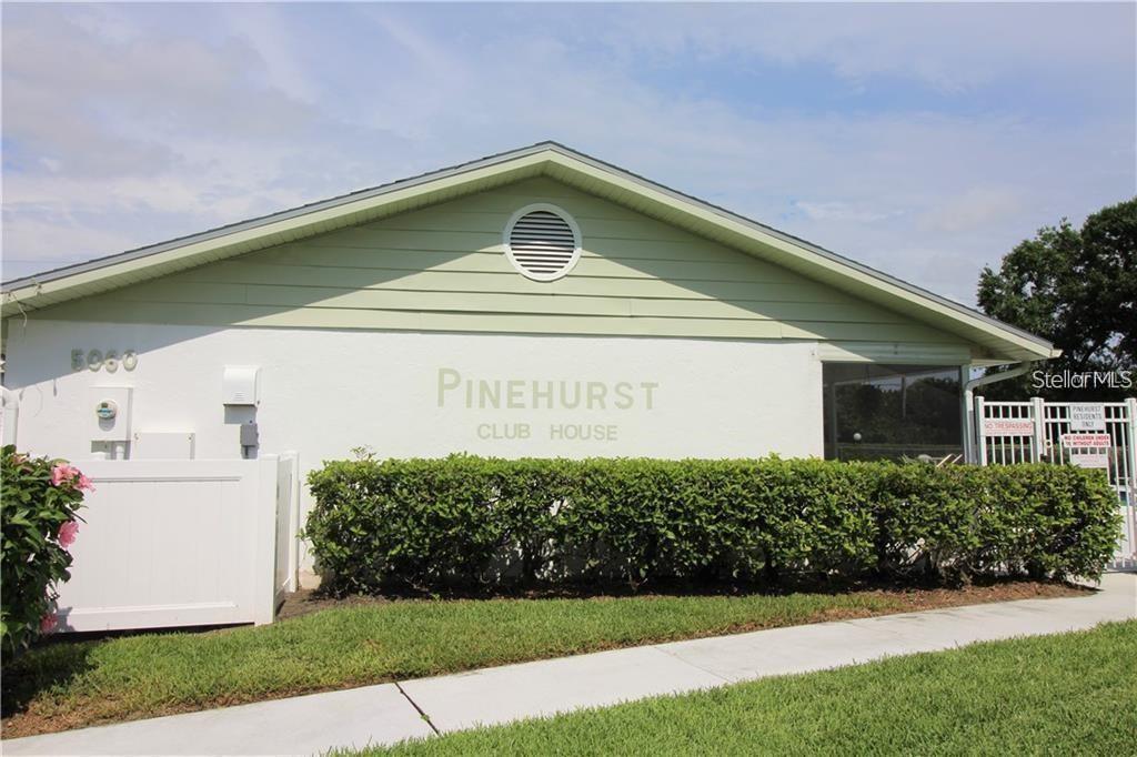 The exterior of a single-story clubhouse building with light green siding and a white wall — 7287 ELEANOR CIRCLE UNIT 15, SARASOTA, FL