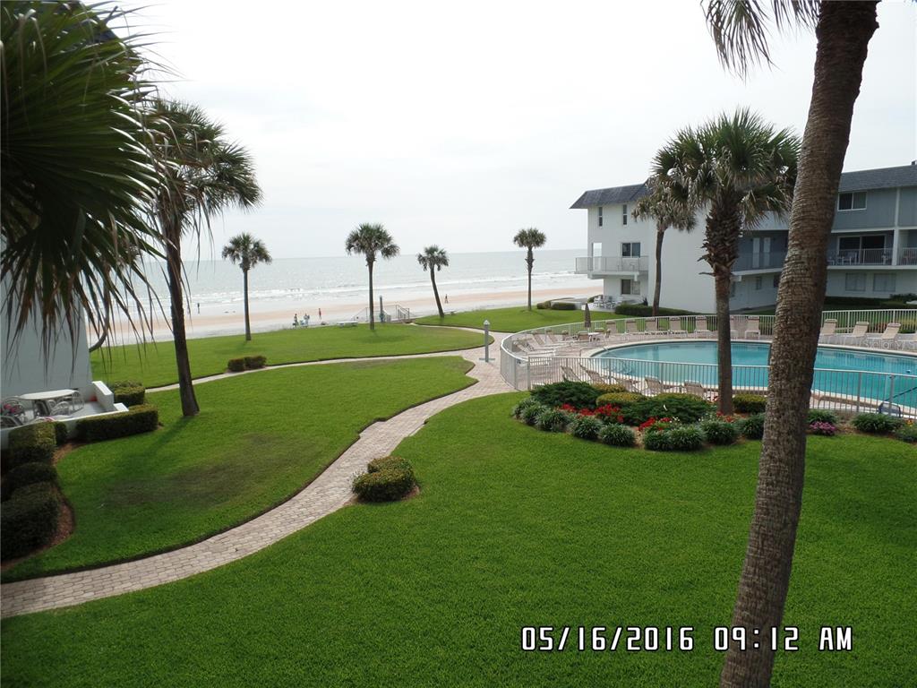 A view of a grassy courtyard with a swimming pool and a path to the beach — 815 OCEAN SHORE BOULEVARD UNIT 10B, ORMOND BEACH, FL