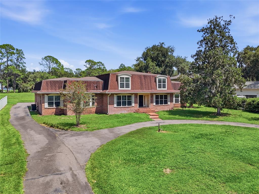 A two-story brick house with a mansard roof and a circular driveway — 6319 SW 37TH WAY, GAINESVILLE, FL