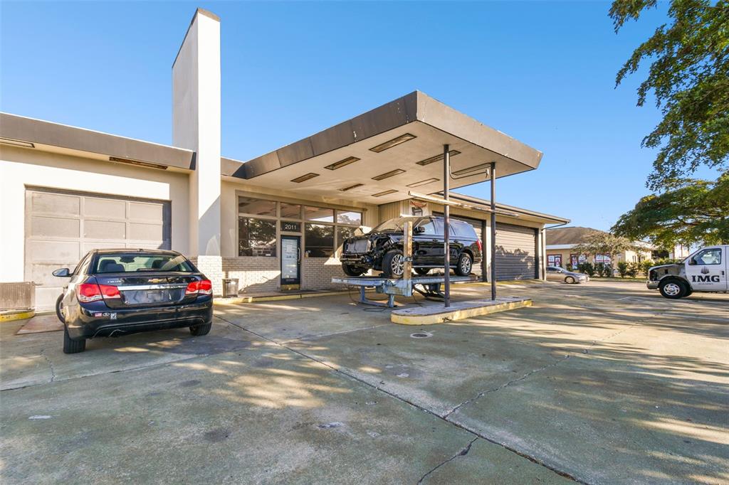 An exterior view of a commercial building with a service bay and a lifted vehicle — 2011 9TH STREET W, BRADENTON, FL