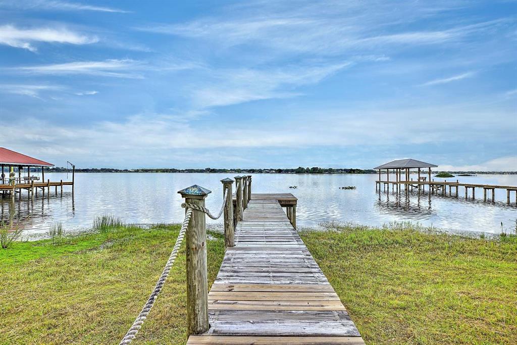 A wooden dock extends into a calm lake under a blue sky with scattered clouds — 4160 LAKEVIEW DRIVE, SEBRING, FL