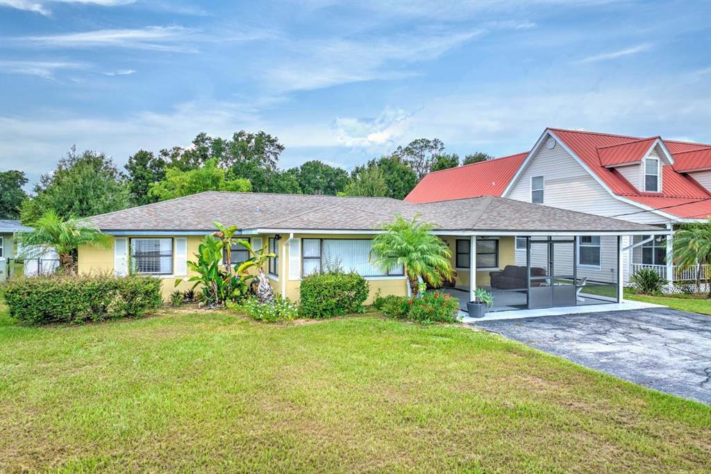 A single-story yellow house with a screened-in porch and a large front lawn — 4160 LAKEVIEW DRIVE, SEBRING, FL