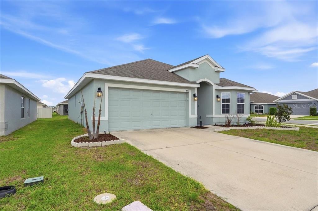 A light green single-story house with a two-car garage and a concrete driveway — 851 VIENNA DRIVE, WINTER HAVEN, FL