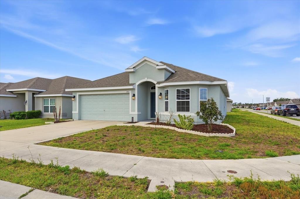 A light green single-story house with a two-car garage and a concrete driveway — 851 VIENNA DRIVE, WINTER HAVEN, FL