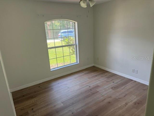 An empty bedroom features light-colored walls, wood-look flooring, and an arched window — 20 UNION RUN COURT, PALM COAST, FL