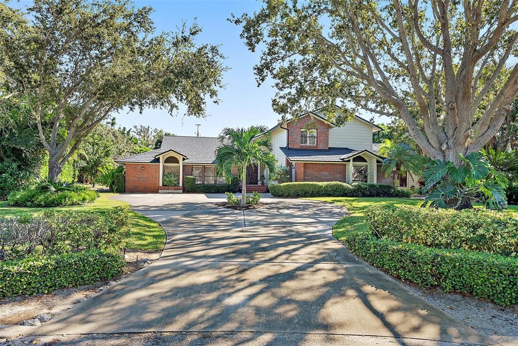 A two-story brick and siding house features a large circular driveway and mature trees — 2371 LANDINGS CIRCLE, BRADENTON, FL