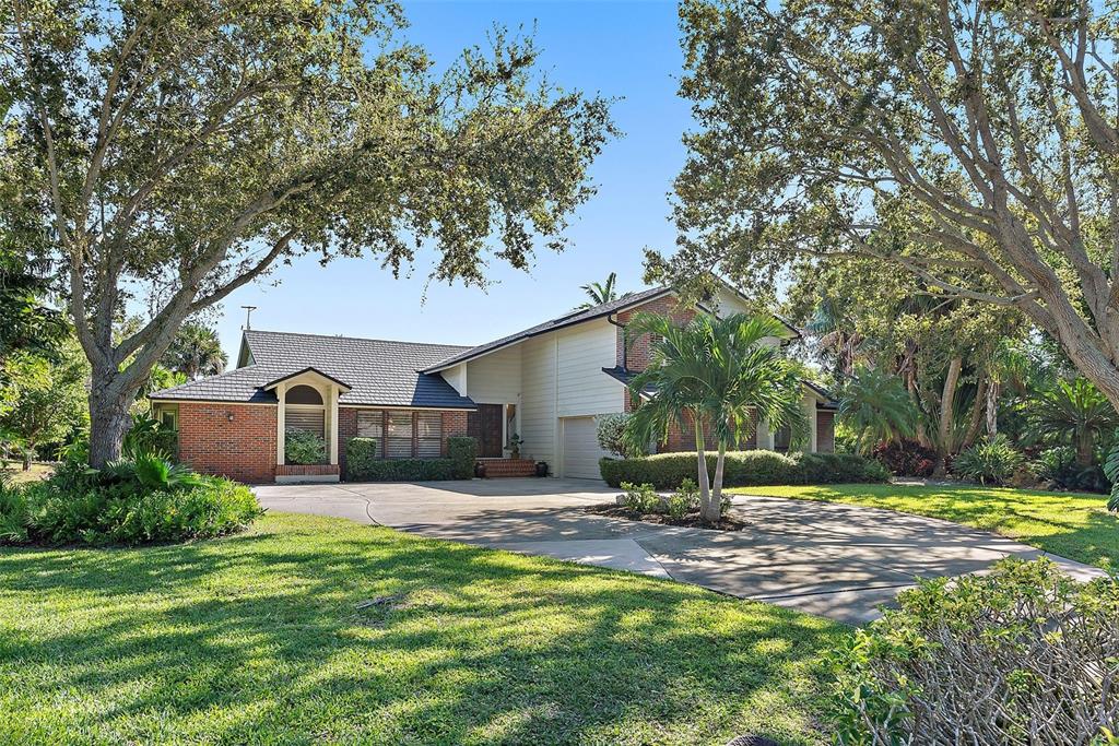 A two-story brick and siding house with a large driveway and mature trees — 2371 LANDINGS CIRCLE, BRADENTON, FL