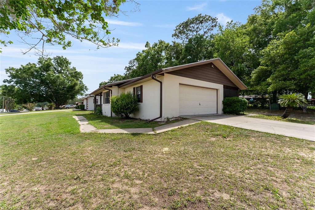 A single-story house with a white exterior, brown trim, and an attached garage — 11300 SE 74TH AVENUE, BELLEVIEW, FL