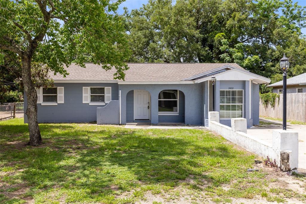 A single-story blue house with a front porch and a low white concrete wall — 3432 HARRY STREET, APOPKA, FL