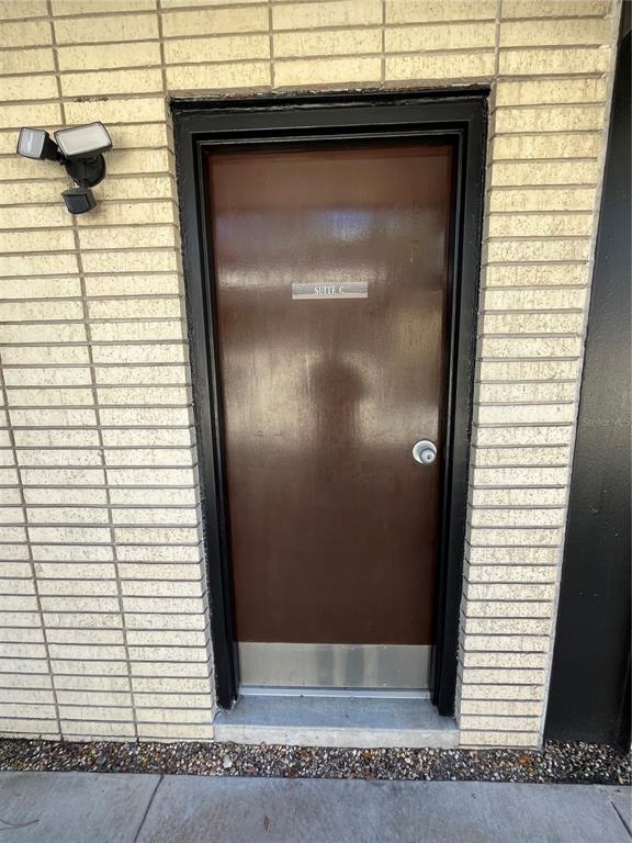 A brown door labeled Suite C is set into a light-colored brick exterior wall — 519 NE 1ST STREET, GAINESVILLE, FL