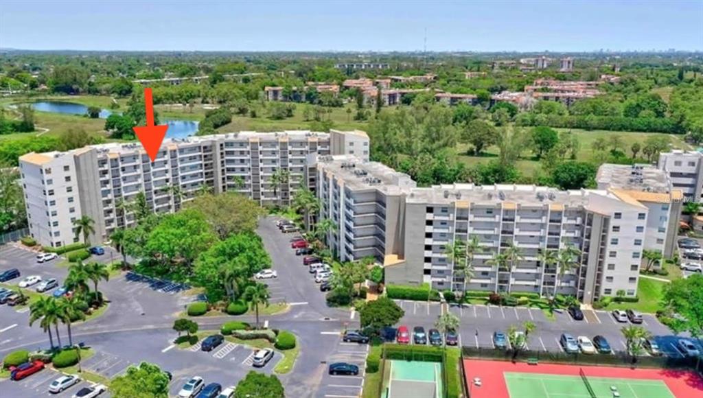 An aerial view shows a multi-story apartment complex with parking lots and tennis courts — 3940 INVERRARY BOULEVARD UNIT 703A, LAUDERHILL, FL