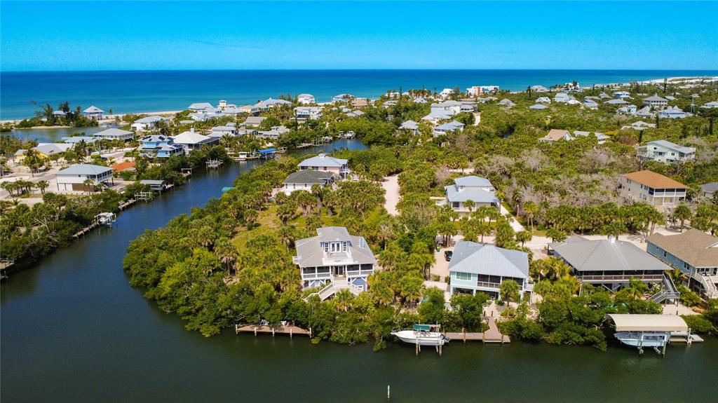 An aerial view of waterfront homes surrounded by dense trees near the ocean — 39 BAYSHORE CIRCLE, PLACIDA, FL