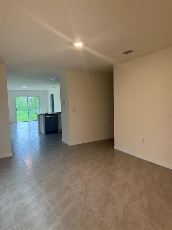 A view from a tiled room looking toward a kitchen with a dark dishwasher — 1663 HAZY SEA DRIVE, PLANT CITY, FL