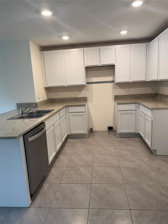 A kitchen with white cabinets, granite countertops, stainless steel dishwasher, and gray tile flooring — 1663 HAZY SEA DRIVE, PLANT CITY, FL