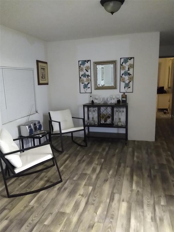 A room features two rocking chairs, a bar cabinet, and light wood-look flooring — 8488 SE 126TH PLACE, BELLEVIEW, FL