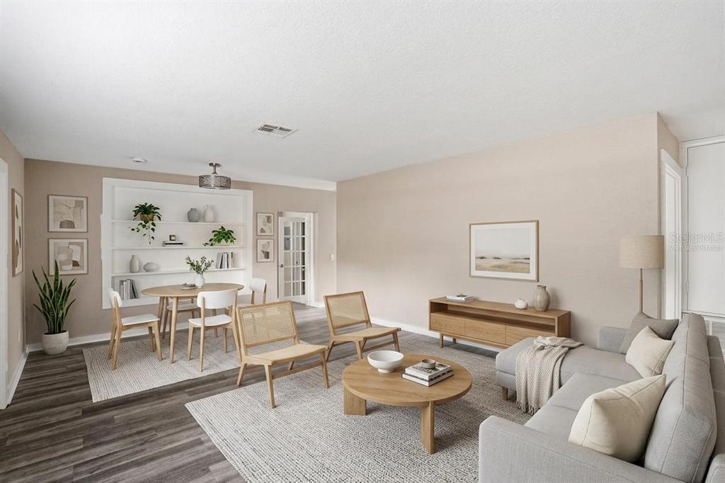 This is a virtually staged living and dining room with light wood furniture and neutral walls — 1514 CREST AVENUE, LEESBURG, FL