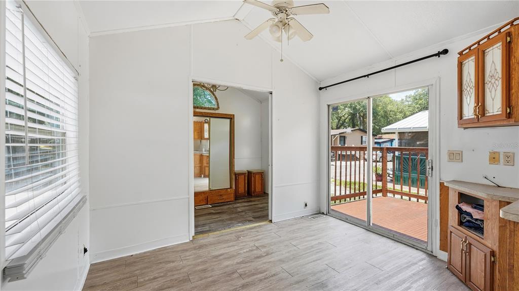 A room with white walls, wood-look flooring, a ceiling fan, and a sliding glass door — 3000 CLARCONA ROAD UNIT 830, APOPKA, FL