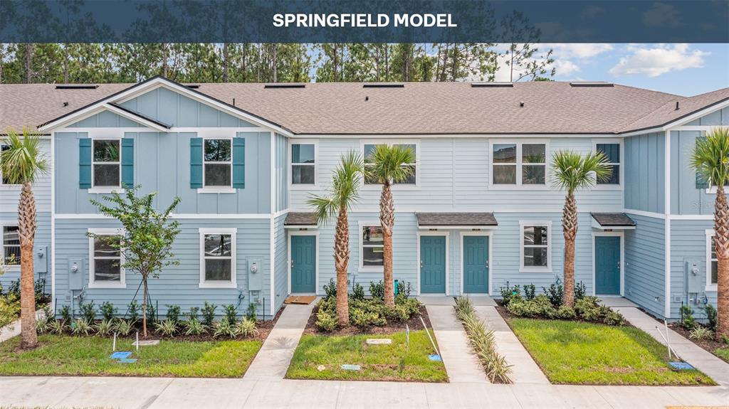A row of light blue two-story townhomes with teal doors and palm trees in front — 273 AYAMONTE ROAD, ST AUGUSTINE, FL