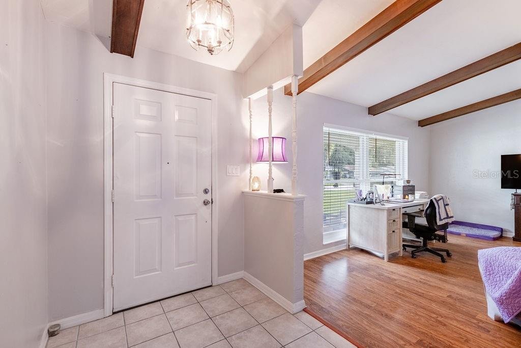 An entryway with tiled floors leads into a living area featuring wood ceiling beams — 4268 LAKE ELEANOR DRIVE, MOUNT DORA, FL