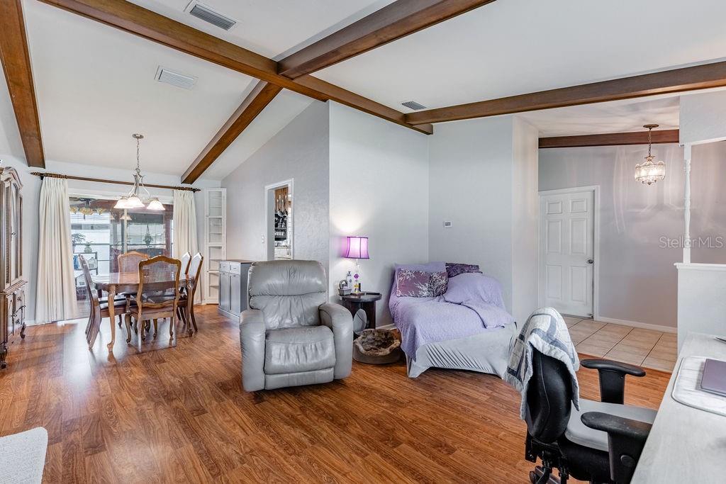 A living and dining area features wood-look flooring, exposed ceiling beams, and a sliding glass door — 4268 LAKE ELEANOR DRIVE, MOUNT DORA, FL