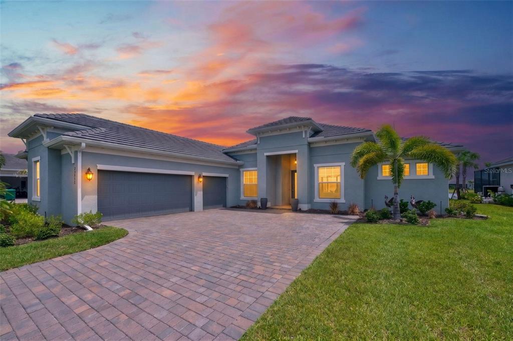 An aerial view of a gray single-story house with a tile roof and paved driveway — 25076 REDWOOD COURT, PUNTA GORDA, FL