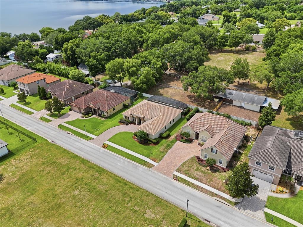 An aerial view shows a row of suburban houses with tiled roofs along a street — 12825 BRUNELLO CIRCLE, CLERMONT, FL