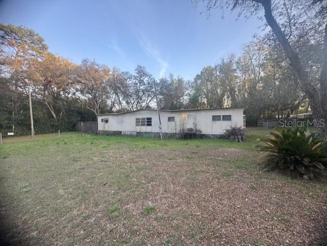 A single-story manufactured home sits on a grassy lot surrounded by trees — 4639 CR 690, WEBSTER, FL