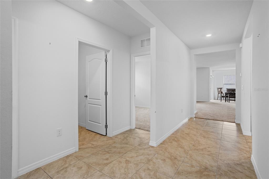 A tiled hallway leads to carpeted rooms and a dining area in the background — 2143 KALIN WAY, TAVARES, FL