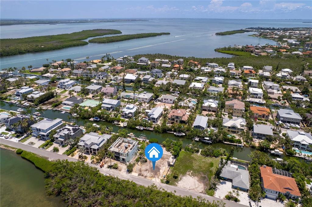 An aerial view shows a vacant waterfront lot with a blue location marker — 640 LYONS LANE, LONGBOAT KEY, FL