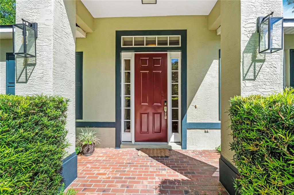 A single-story house with a light yellow exterior, dark shutters, and a central front entrance — 1085 TAYLOR ROAD E, DELAND, FL