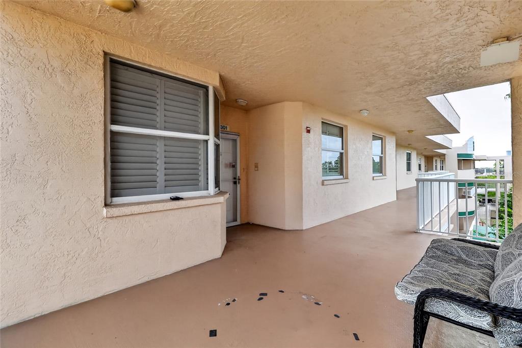 An outdoor balcony with a beige stucco wall, a window, and a white metal railing — 6251 SHORELINE DRIVE UNIT 2301, SEMINOLE, FL