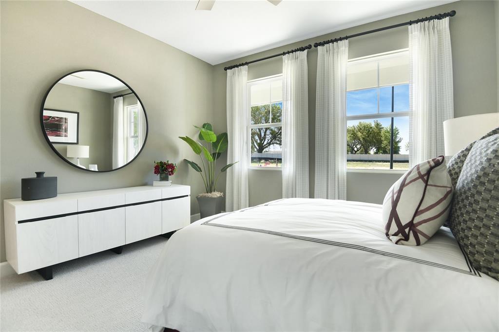 A bedroom features a white dresser, a round mirror, a potted plant, and a bed — 1261 DAISY HILL AVENUE, DUNDEE, FL