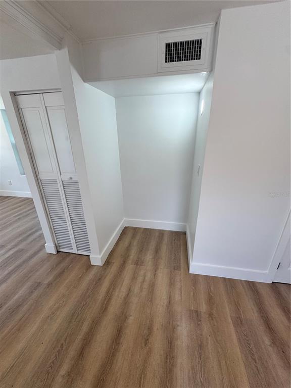 An empty alcove with wood-look flooring and a white louvered closet door nearby — 309 E WOODWARD AVENUE, EUSTIS, FL