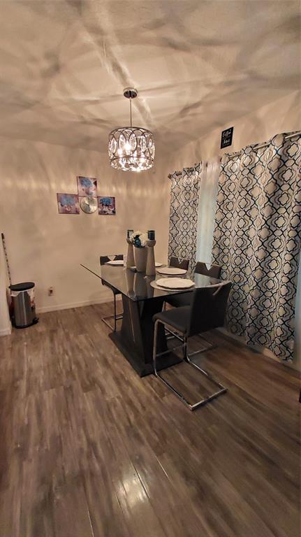 A dining area with wood-look flooring, a window, a table, and an open front door — 355 GRANADA BOULEVARD, DAVENPORT, FL