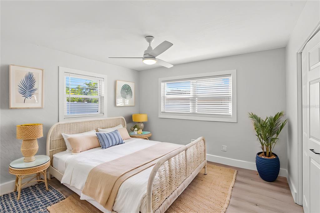 A bedroom features a rattan bed frame, light gray walls, and a ceiling fan — 2003 6TH PLACE SW, LARGO, FL
