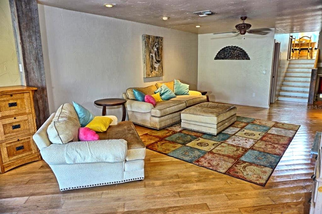 A living room features a multi-colored area rug, two beige sofas, and hardwood flooring — 1859 MAZO MANOR UNIT U6, LUTZ, FL